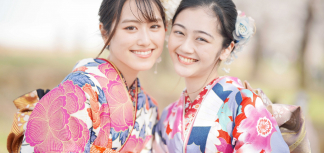 着物を着た笑顔の女性2人が顔を寄せ合っている